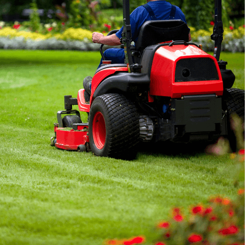 image d'un ouvrier en train de tondre le gazon